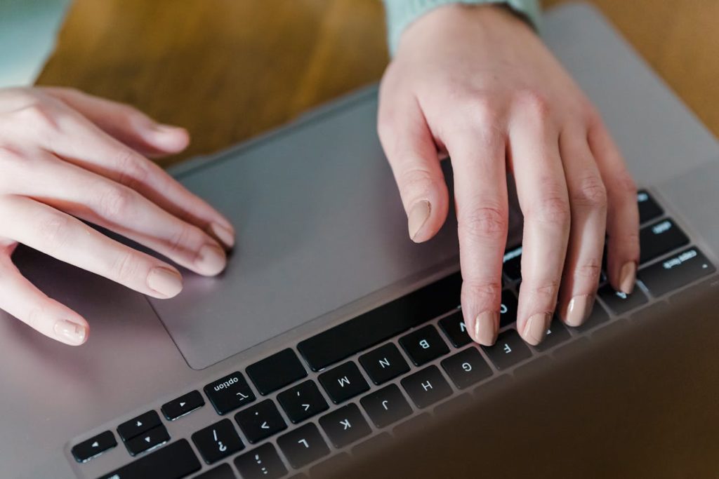 Mains d'une femme tapant sur le clavier d'un ordinateur.