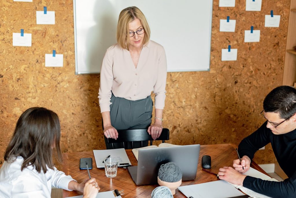 Trois personnes dans une salle, l'une briefe les deux autres sur de la rédaction de contenus pour le web.