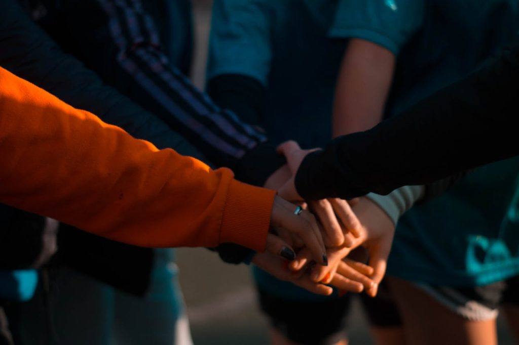 Image de plusieurs personnes se mettant les mains les unes sur les autres.