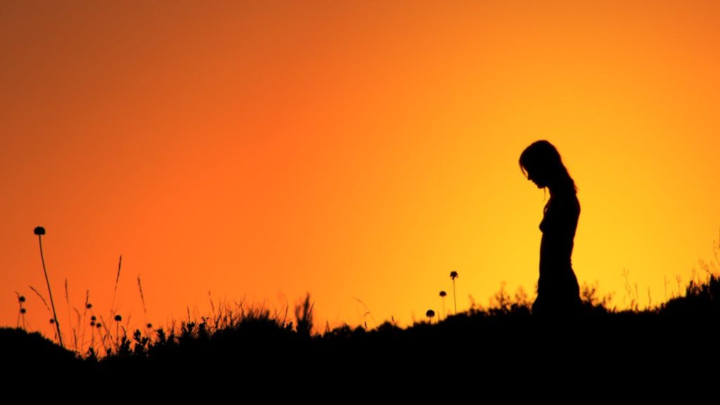 Image d'une jeune femme dans la lumière du soleil couchant pour représenter le persona d'une entreprise.