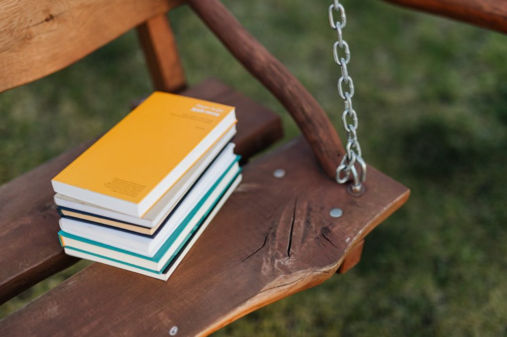 Livres posés sur une balançoire en bois.