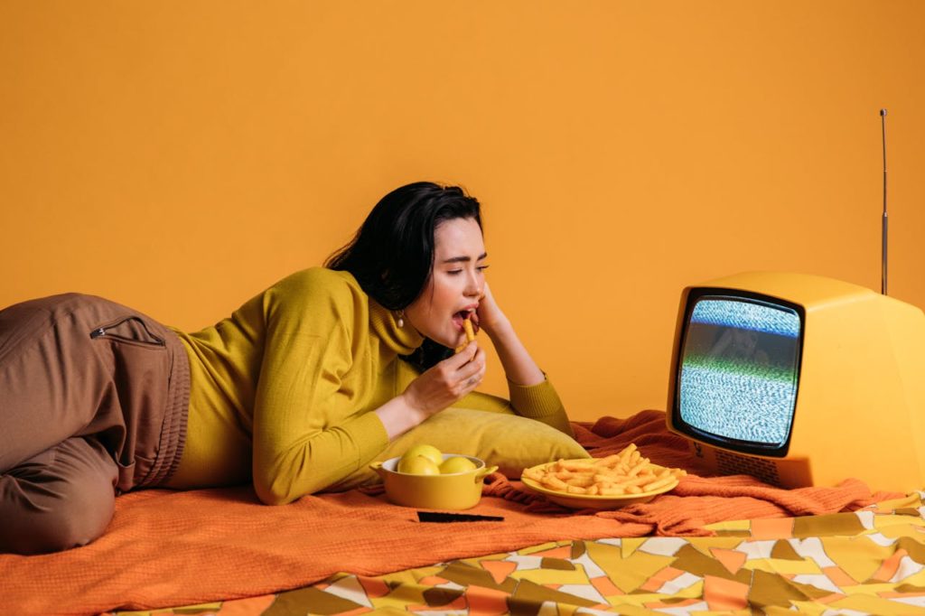 Image d'une jeune femme allongée devant une petite télévision pour illustrer la référence culturelle.