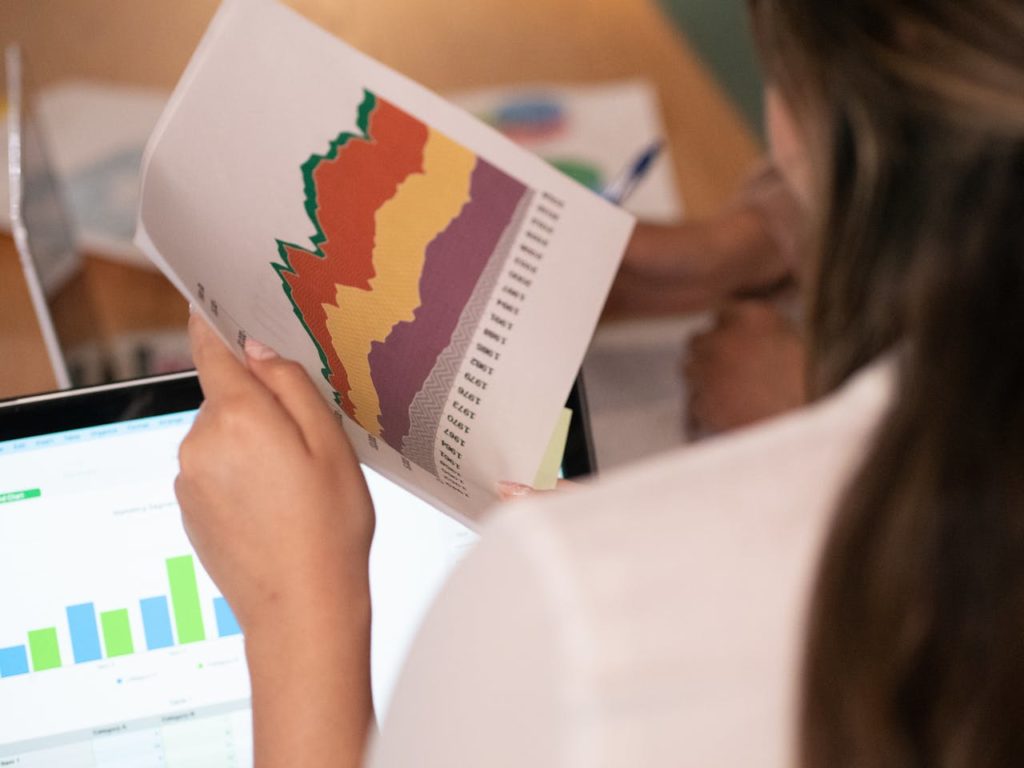 Image d'une femme tenant des papiers avec des statistiques dans les mains.