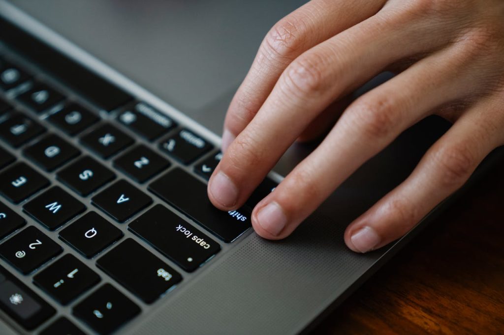 Gros plan sur un clavier d'ordinateur et une main.