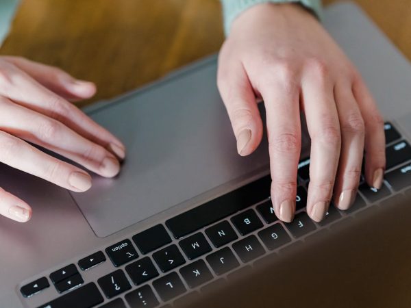 Mains d'une femme tapant sur le clavier d'un ordinateur.