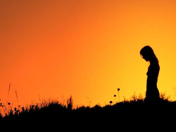 Image d'une jeune femme dans la lumière du soleil couchant pour représenter le persona d'une entreprise.