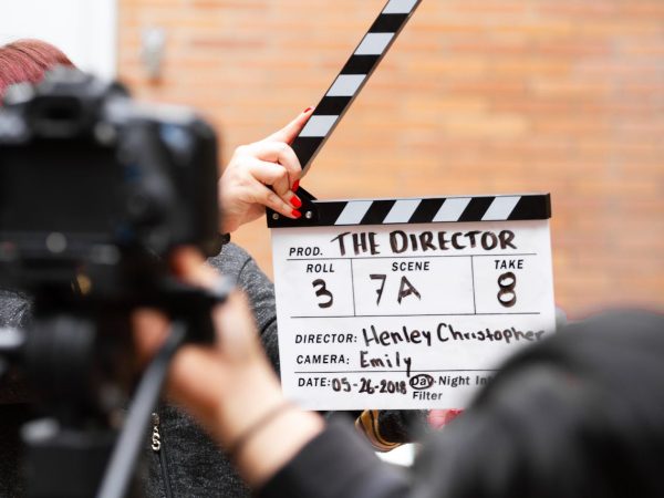 Clap de cinéma sur fond de briques pour illustrer l'importance de la vidéo dans votre image de marque.